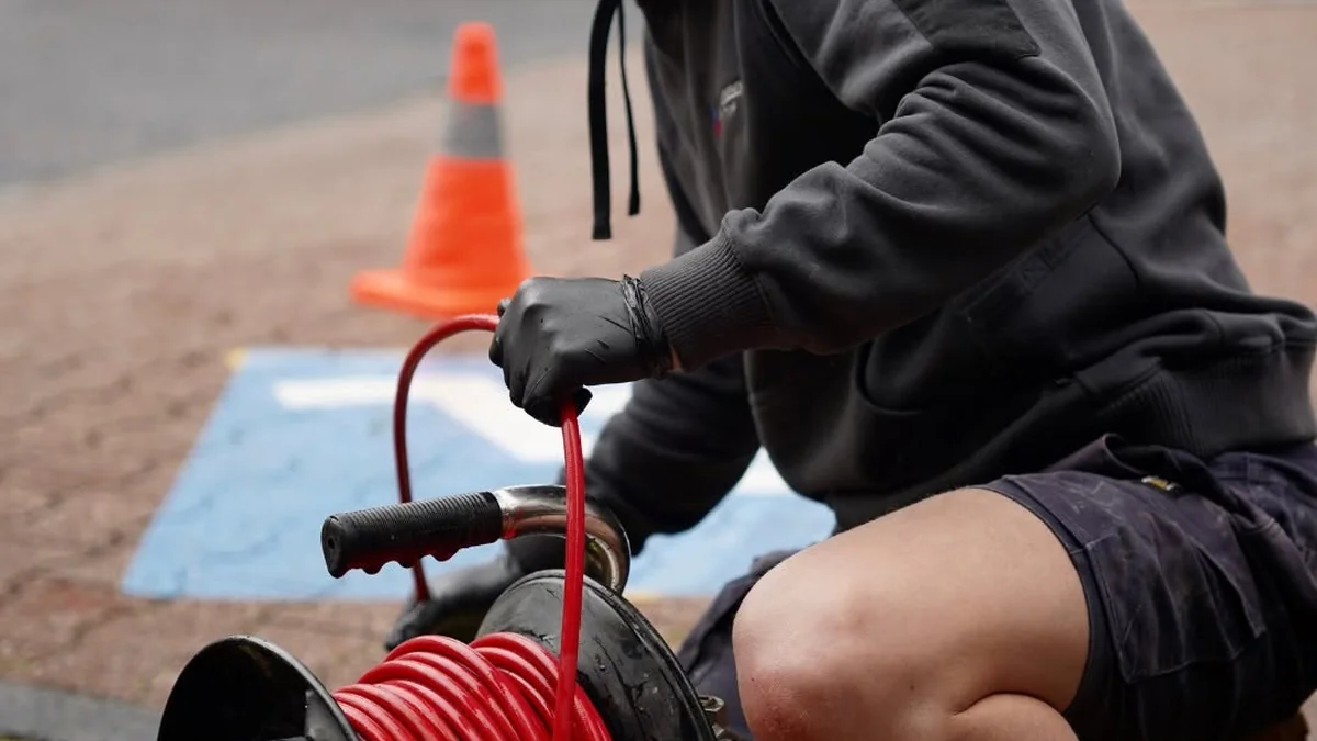 Adelaide Elite Emergency Plumbing technician using high-pressure water jetting to clear a blocked drain on-site